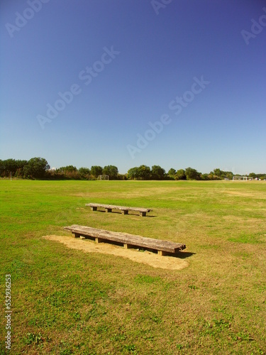 秋の江戸川河川敷の古いベンチのあるサッカー場風景