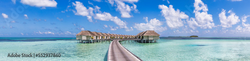 Amazing Maldives, travel panorama. Luxury resort villas seascape with sunny blue sky, tranquil ocean lagoon. Wooden walkway. Tropical paradise inspiration. Wallpaper banner exotic vacation destination
