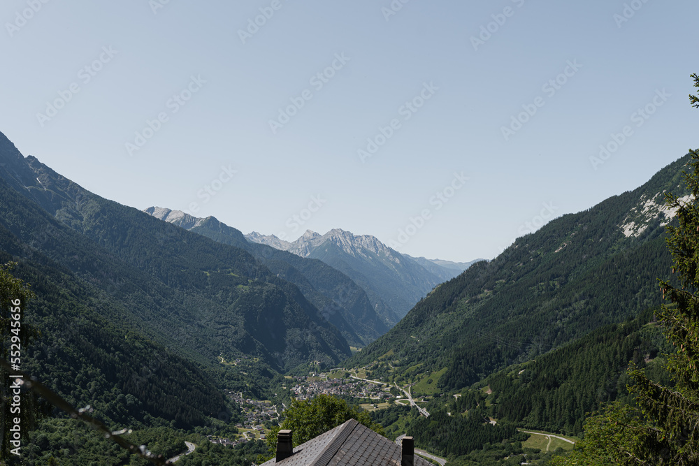 Country house cottage roof, mountains, valley, forest, sky with clouds. Landscape