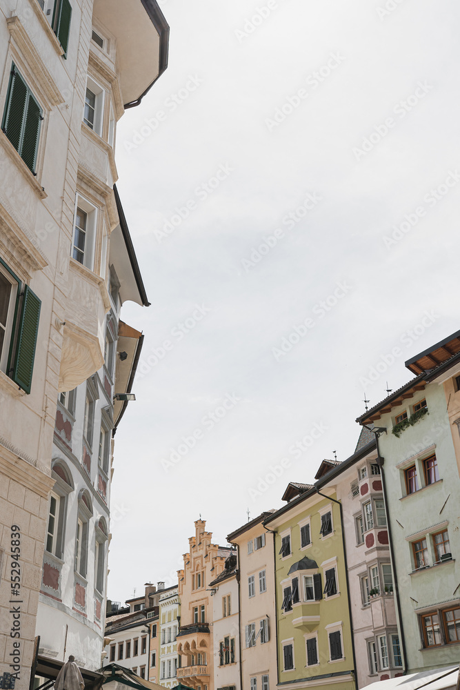 Historic architecture in Italy. Traditional European old town street buildings. Wooden windows, shutters and colourful pastel walls. Aesthetic summer vacation travel background