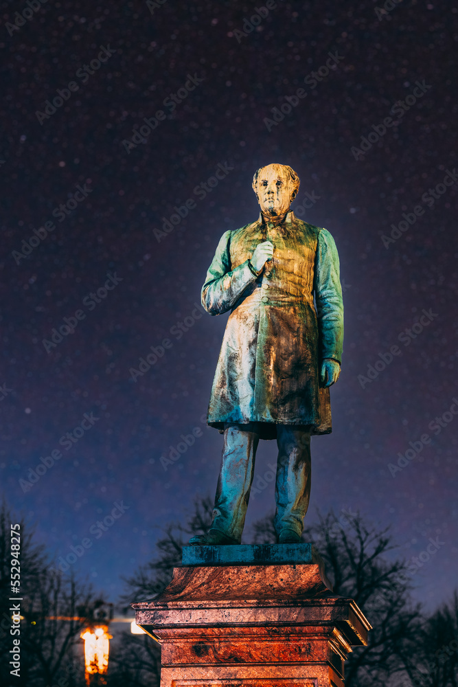 Colourful Night Starry Sky In Blue Colors. Close Up Of Statue Of Johan Ludvig Runeberg On Esplanadi Park In Lighting At Night Illumination. Helsinki, Finland. National Poet And Lyric Of Finland. Colourful Night Starry Sky In Blue Colors. Close Up Of Statue Of Johan Ludvig Runeberg On Esplanadi Park In Lighting At Night Illumination. Helsinki, Finland. National Poet And Lyric Of Finland.
