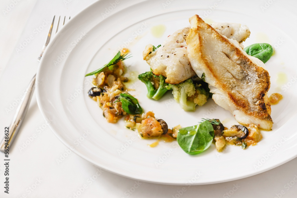 fish with vegetables on the white plate