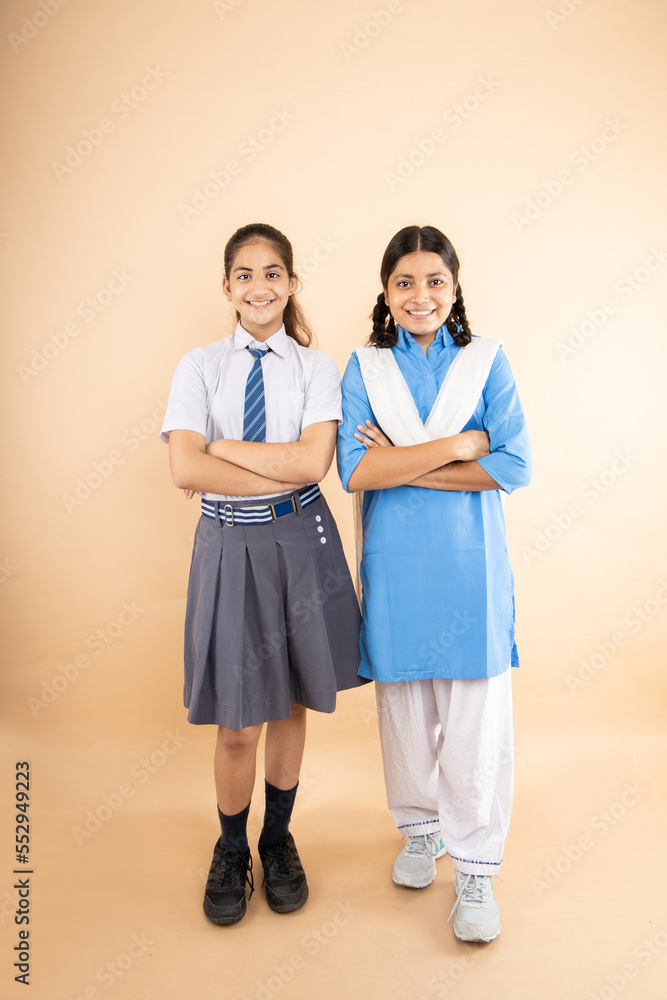 Happy Rural and Modern Indian student schoolgirls wearing school uniform  standing folded hands together isolated over beige background, Full length,  Studio shot, Education concept. Stock Photo | Adobe Stock