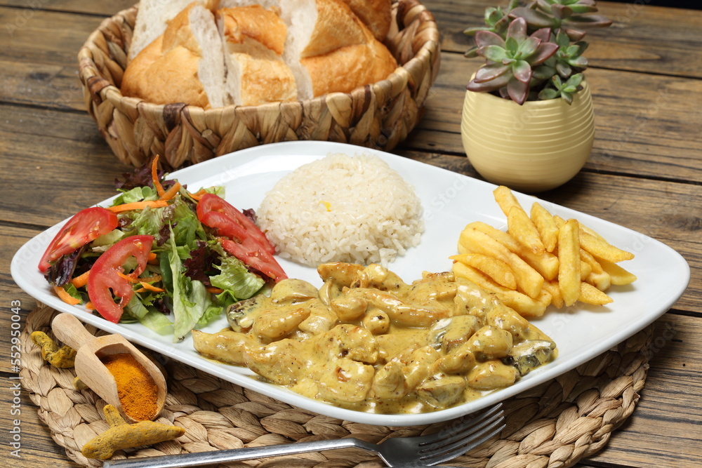 curry chicken served with fries potato, salad and rice pilaf