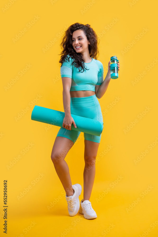 cheerful athlete in sportswear with fitness mat and sport bottle in studio. fitness athlete cheerful athlete in sportswear with fitness mat and sport bottle in studio. fitness athlete