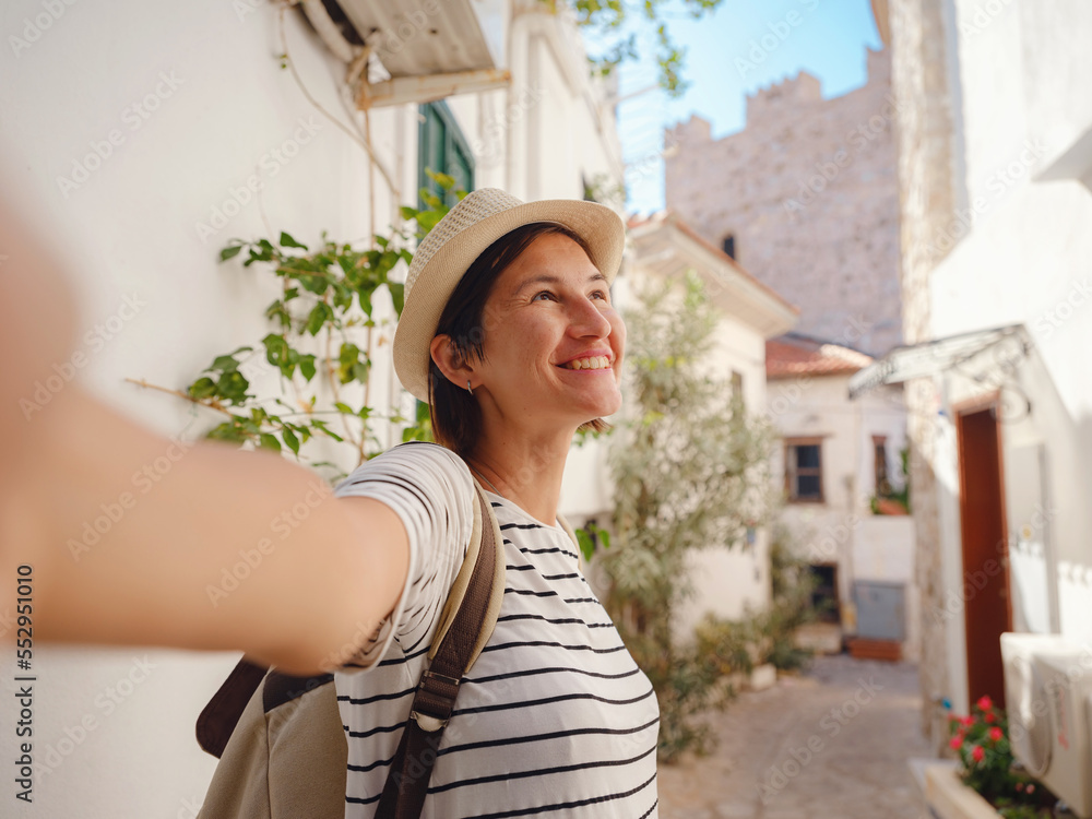 Marmaris is resort town on Turkish Riviera, known as Turquoise Coast. Marmaris is great place for sailing and diving. Tourist Woman on Beautiful Streets of old Marmaris taking selfie on smartphone.