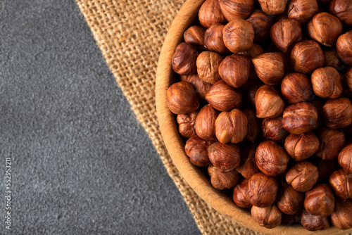 Top view of a bowl full of hazelnuts on dark background 