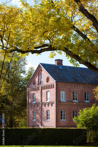 The building Biskopshuset in Lund Sweden during warm autumn day with fall colored leaves on trees