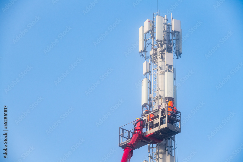 Déploiement du réseau 5G. Pose d'antennes sur un mat de téléphonie mobile dans la brume hivernale Déploiement du réseau 5G. Pose d'antennes sur un mat de téléphonie mobile dans la brume hivernale