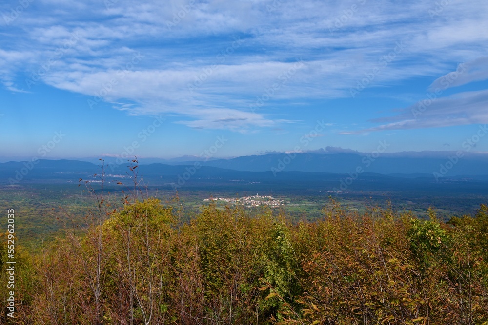 View of Karst plateau with Pliskovica village and Trnovo forest plateau behind in Primorska, Slovenia View of Karst plateau with Pliskovica village and Trnovo forest plateau behind in Primorska, Slovenia