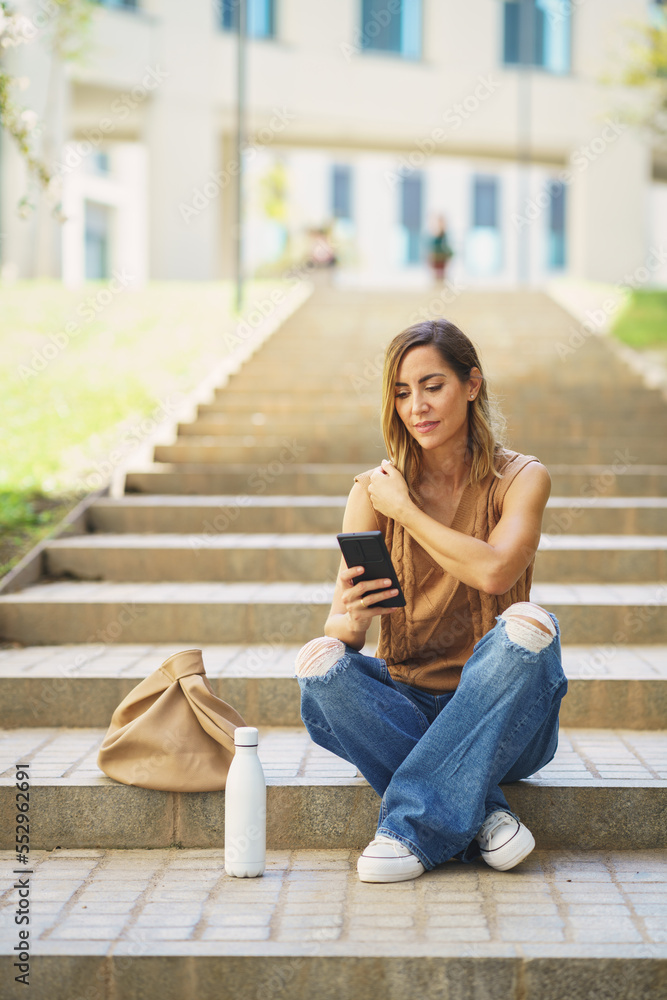 Female with smartphone sitting on stairs Female with smartphone sitting on stairs
