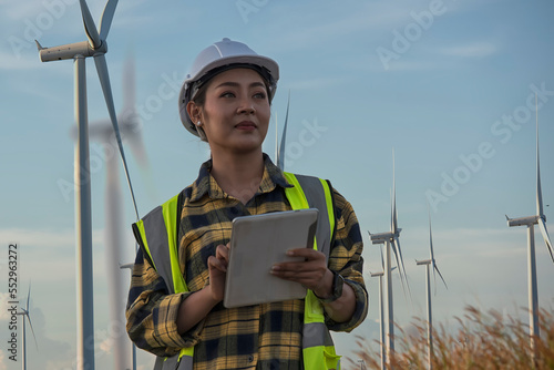 Portrait woman engineer using tablet on wind turbine on background.