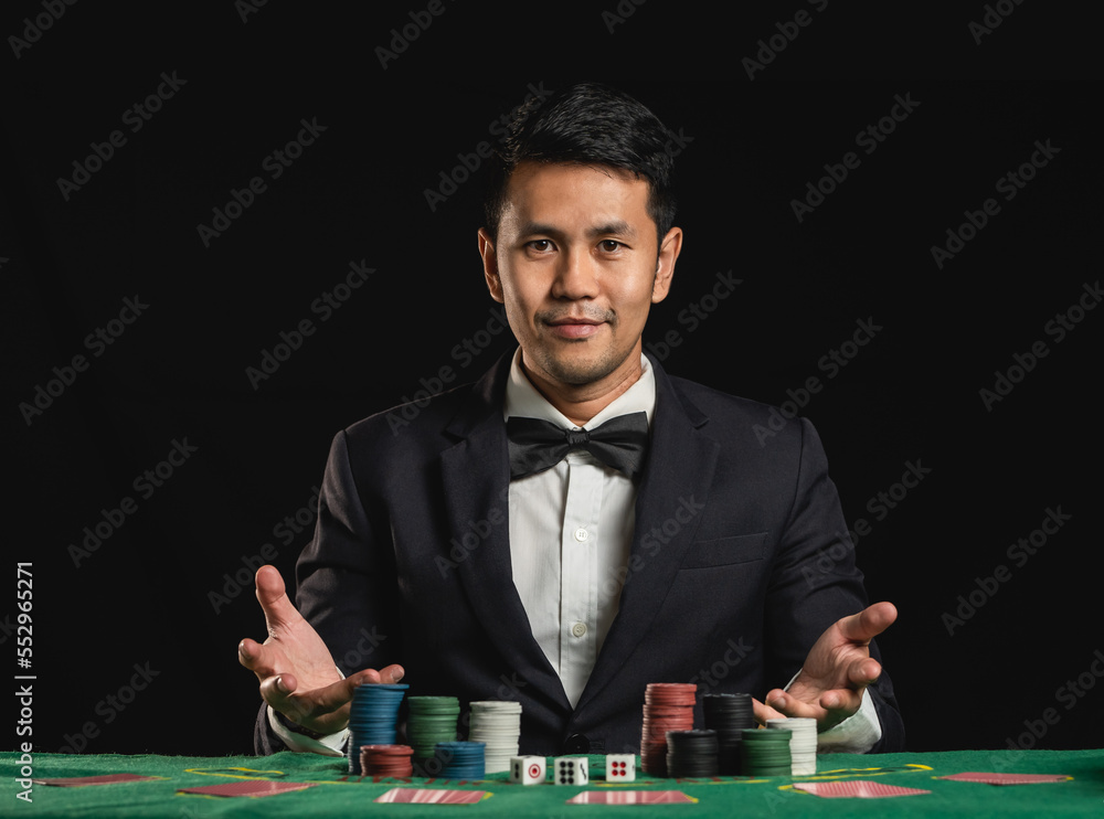 Ταπετσαρία Asian man dealer or croupier shuffles poker cards betting in casino on black background of green table, Dealer man invitation bet playing cards