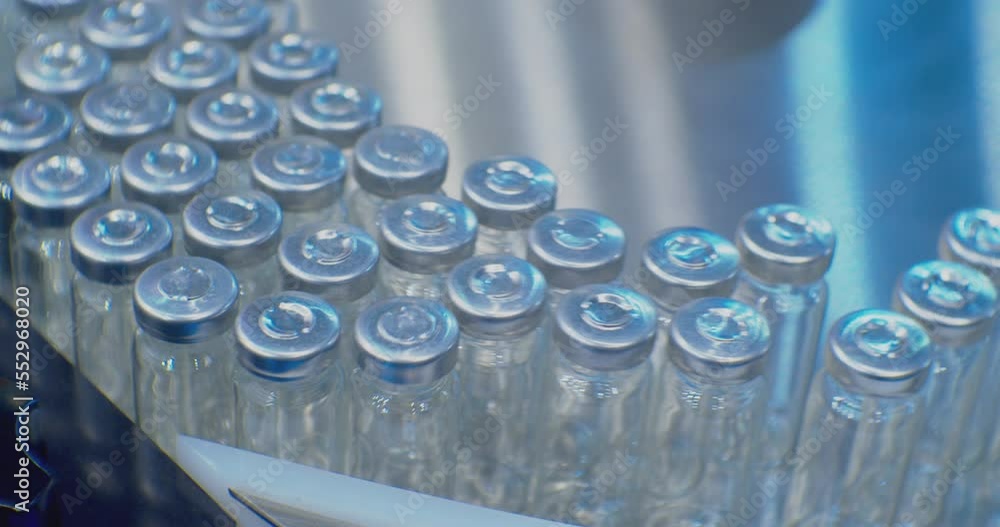 pharmaceutical industry.automatic production line machine conveyor with empty glass bottles at pharmacy processing factory. Medicine manufacturing and automated technology equipment.close-up. pharmaceutical industry.automatic production line machine conveyor with empty glass bottles at pharmacy processing factory. Medicine manufacturing and automated technology equipment.close-up.
