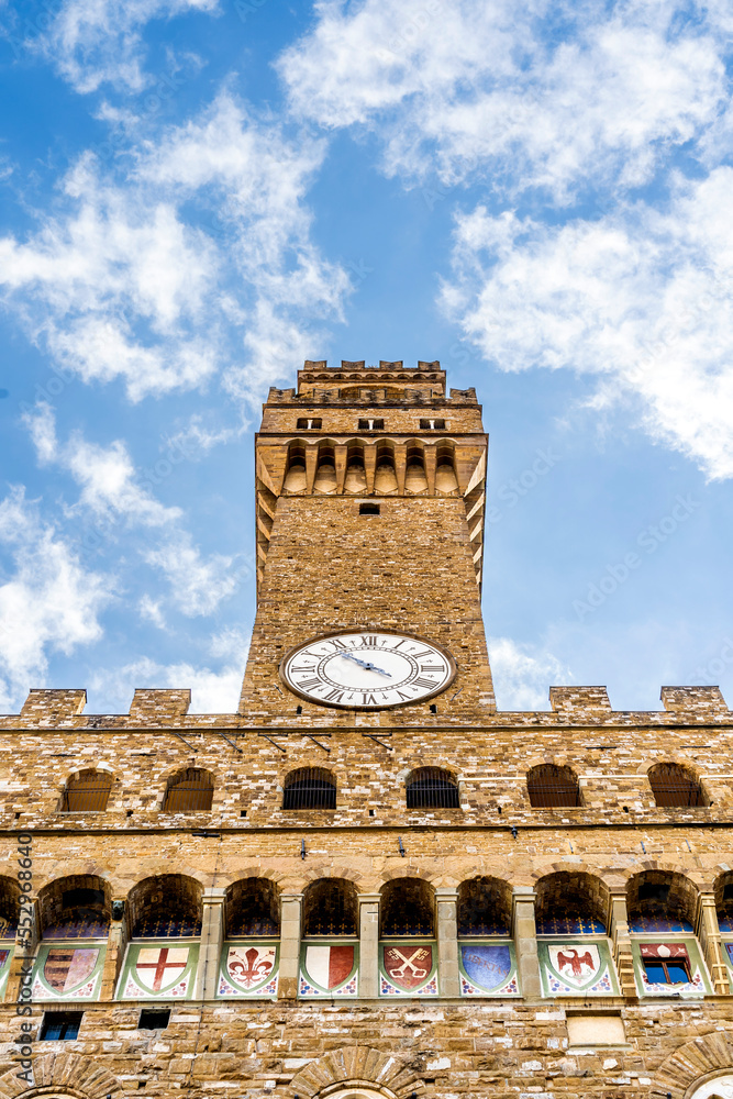 Close up on the Volognana tower, in the façade of Palazzo Vecchio with Florentine red lily and coats of arms, Florence city center, Tuscany region, Italy