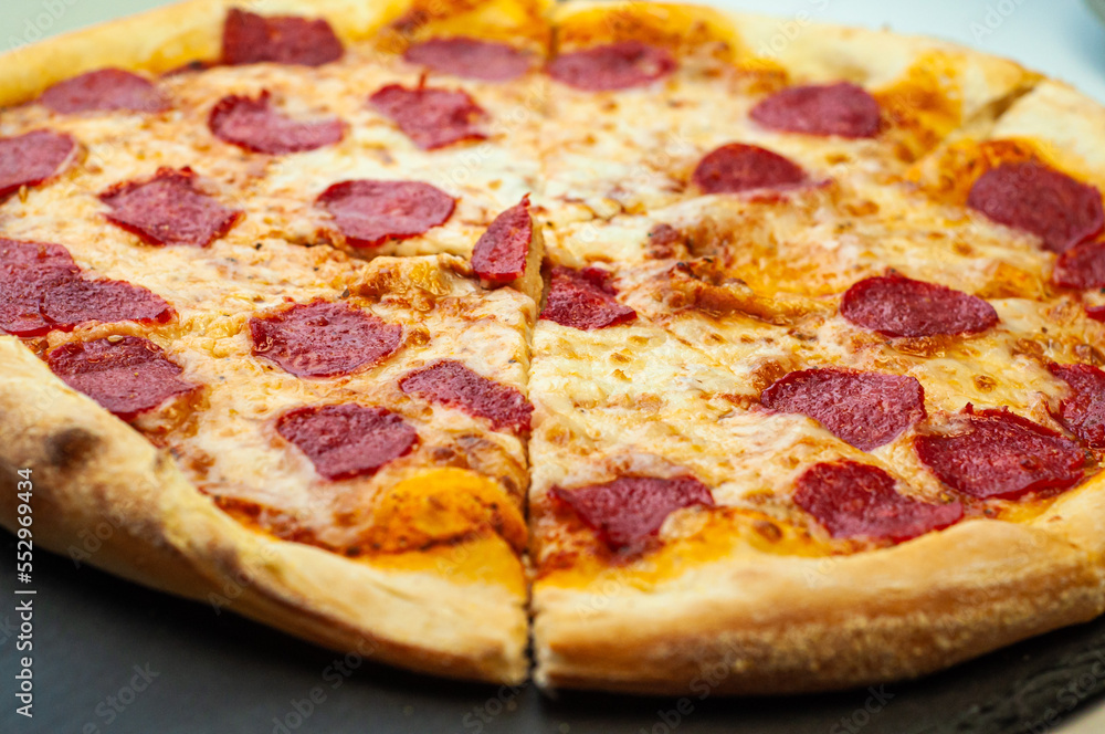 classic traditional dish pepperoni pizza with sausage Italian cuisine on a black background classic traditional dish pepperoni pizza with sausage Italian cuisine on a black background