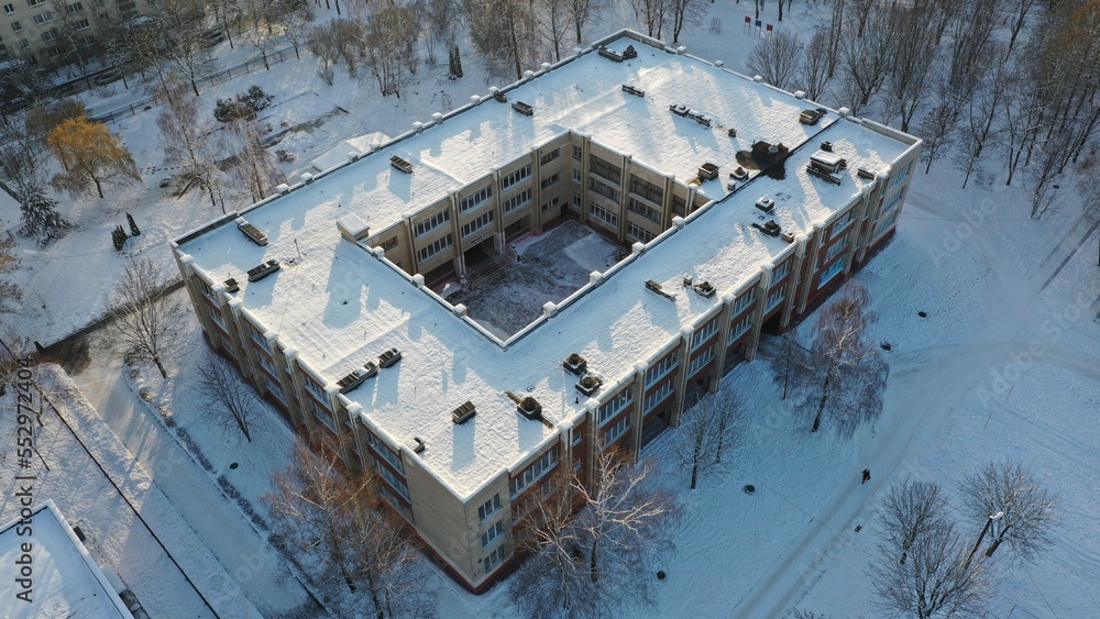 Obraz na płótnie Typical architecture of the Soviet school. What a school building in the USSR looks like under the snow in winter. Typical project of a school in the Soviet Union. Eastern Europe in winter under snow. w salonie