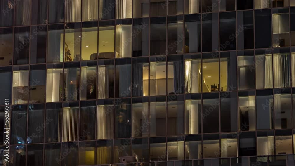 Night aerial view of apartment building glass window facade with illuminated lighted workspace rooms timelapse. Blinking light in skyscraper Night aerial view of apartment building glass window facade with illuminated lighted workspace rooms timelapse. Blinking light in skyscraper