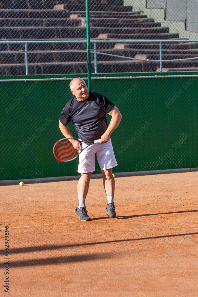 Adult man on the tennis court. Activity, sports and health. Vertical. Adult man on the tennis court. Activity, sports and health. Vertical.