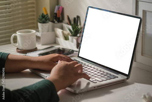 Cropped image of female freelancer using laptop computer. Blank screen for your advertise design..