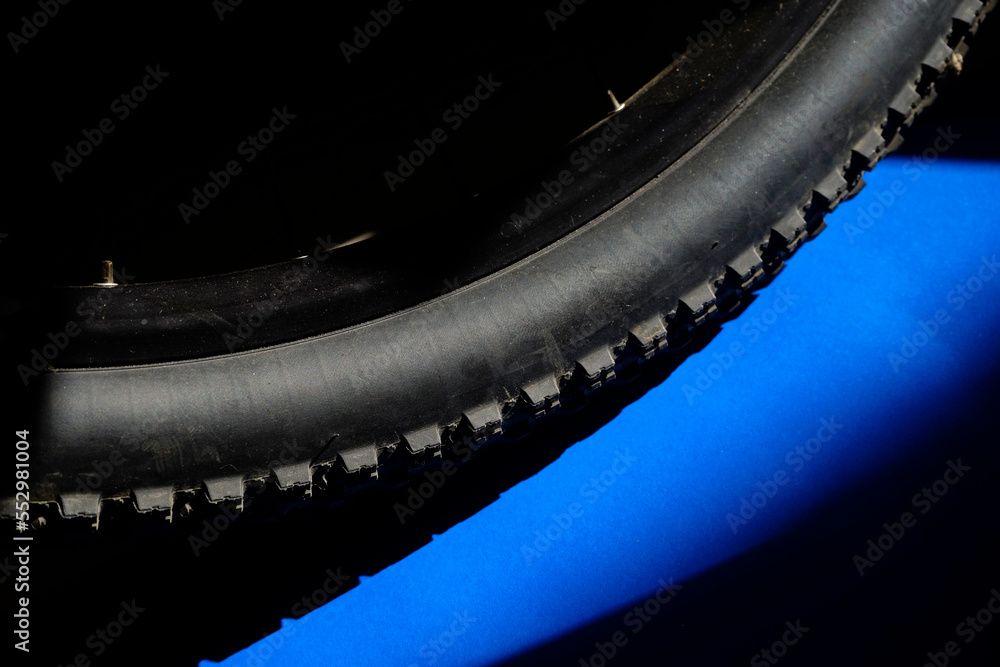 Mountain bike tire on blue black background with copy space