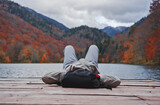A man relaxed lying on a wooden mol near the lake
