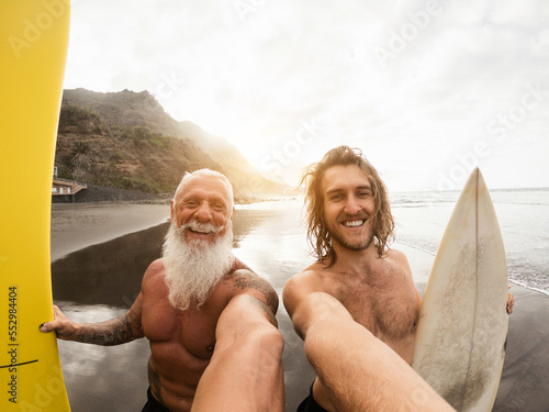 Foto Father and son having fun doing selfie on the beach after surf session - Soft fo