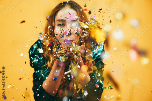 Leinwand Poster Hppy girl blowing confetti - Party and new year's eve concept - Focus on hands h