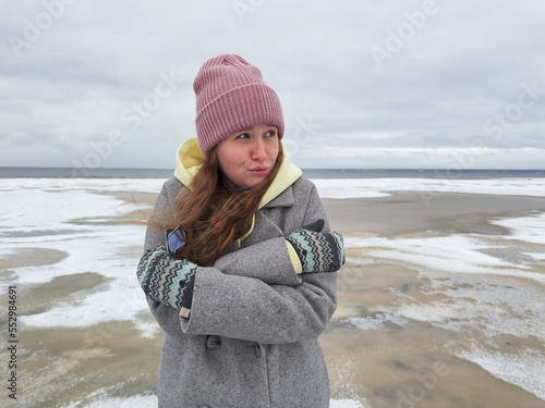 Принти на полотні Frozen young beautiful woman is freezing outdoors on winter cold snowy beach, sh