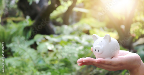 Close up woman hands holding piggy bank carefully for future life. Investment and Saving Concept.