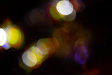 Colorful bokeh on black background. Abstract lights bokeh background. Lines of light bokeh circles on dark background. Lens Flares natural effect. Can be used as background or overlay.