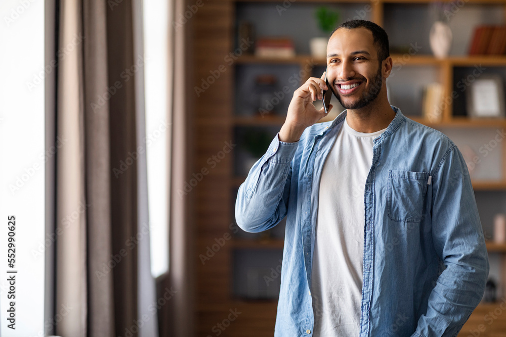 Portrait Of Smiling Handsome Black Man Talking On Cellphone At Home Portrait Of Smiling Handsome Black Man Talking On Cellphone At Home