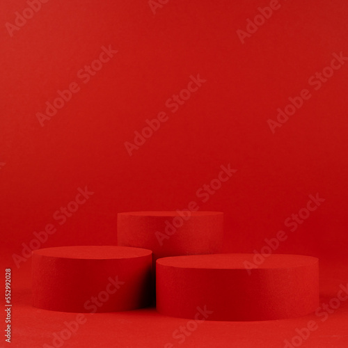 Fotomurale Festive elegant saturated red stage with two cylinder podiums on table for presentation cosmetic products, gifts, goods in luxury modern style, copy space, square