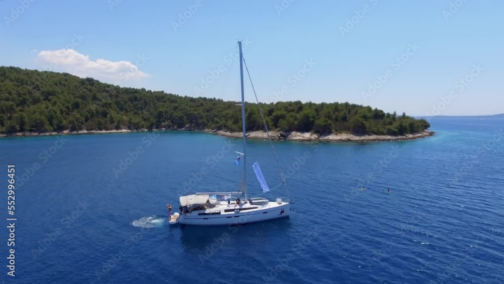 Aerial view beautiful white yacht at anchorage against the backdrop of an authentic Croatian island in the mediterranean sea. Complete calm Aerial view beautiful white yacht at anchorage against the backdrop of an authentic Croatian island in the mediterranean sea. Complete calm