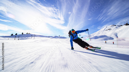 Fotografie professional skier skiing on slopes in the Swiss alps towards the camera