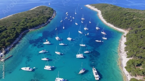 Aerial view beautiful bay of a Croatian island in the mediterranean sea, many identical white yachts at the pier on a sunny summer day photo