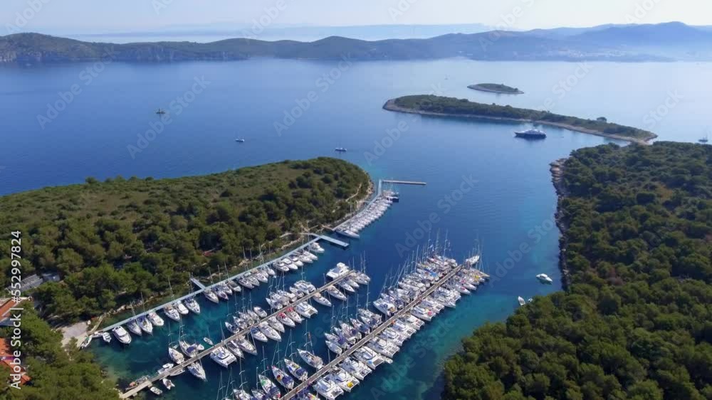 Aerial view beautiful bay of a Croatian island in the mediterranean sea, many identical white yachts at the pier on a sunny summer day Aerial view beautiful bay of a Croatian island in the mediterranean sea, many identical white yachts at the pier on a sunny summer day