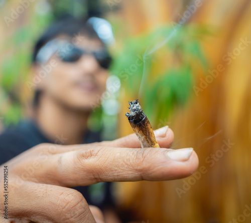 Young man smoking cigarettes with medical marijuana