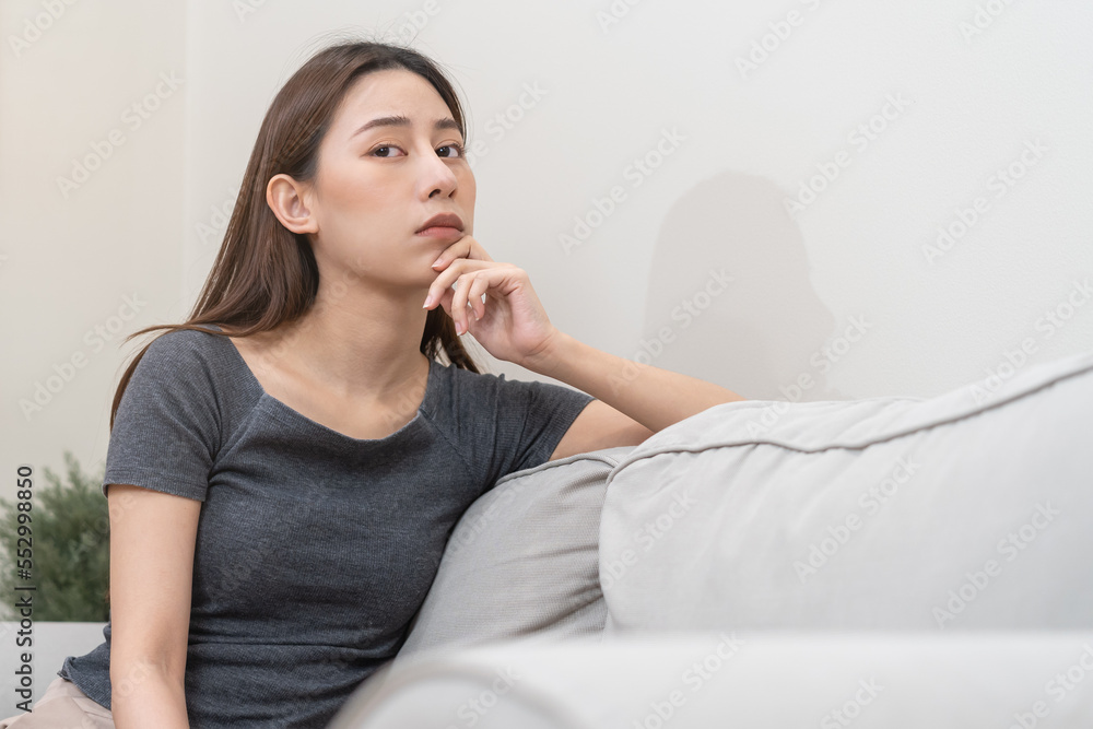 Mental health, depressed sad asian young woman, girl sitting on sofa, couch, expression to face difficulty, failure and exhausted. Thoughtful worried suffering depression feeling lonely, alone at home Mental health, depressed sad asian young woman, girl sitting on sofa, couch, expression to face difficulty, failure and exhausted. Thoughtful worried suffering depression feeling lonely, alone at home