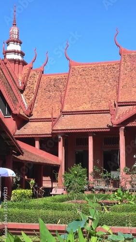 Vertical video of Panning shot of the garden of the National Museum of Cambodia in Phnom Penh with its red buildings.