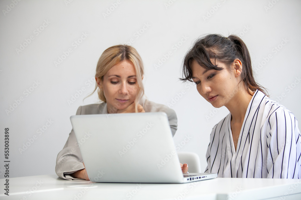 business team female colleagues talking at work share ideas with laptop, Happy colleagues work together on computer in office. business team female colleagues talking at work share ideas with laptop, Happy colleagues work together on computer in office.