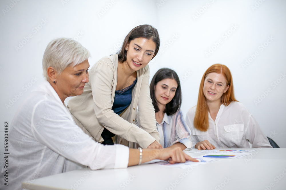 Business team colleagues talking at work share ideas with data report in hands, Happy colleagues work together in office, CEO executive in corporate office. Business team colleagues talking at work share ideas with data report in hands, Happy colleagues work together in office, CEO executive in corporate office.
