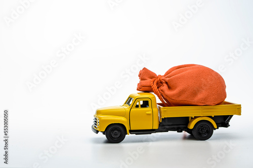 yellow pickup truck with a bag isolated on a white background. Gift concept