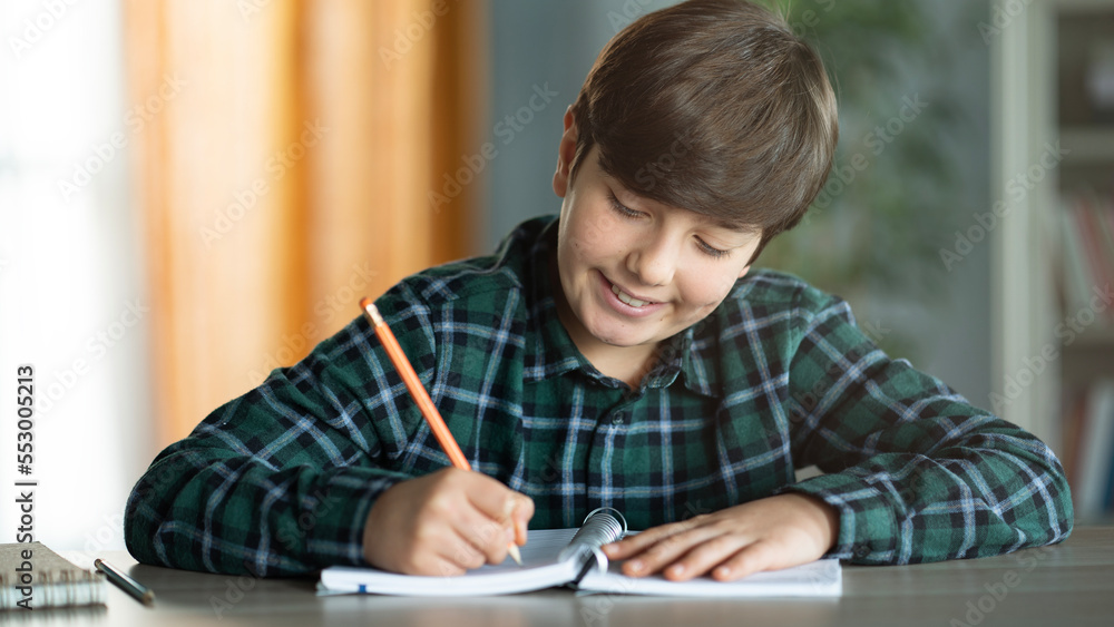 The child writes in notebook The child writes in notebook