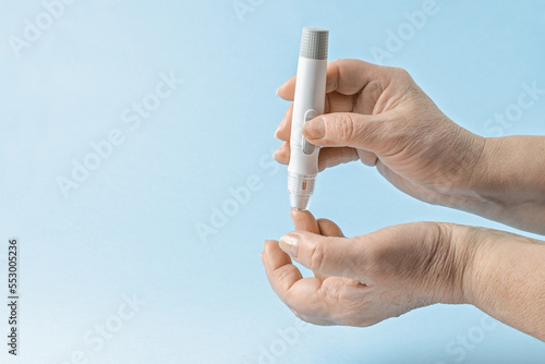 Close-up Of elderly woman Hand Holding Sugar Level Checking Machine