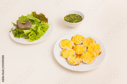 Banh can, Vietnamese mini pancake with with rice batter, egg, sauce and vegetables vietnamese food isolated on white background, perspective view