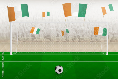 Ivory Coast football team fans with flags of Ivory Coast cheering on stadium, penalty kick concept in a soccer match.