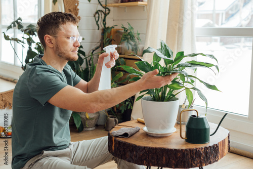 Middle age man taking care of plants at home. Concept of home gardening.