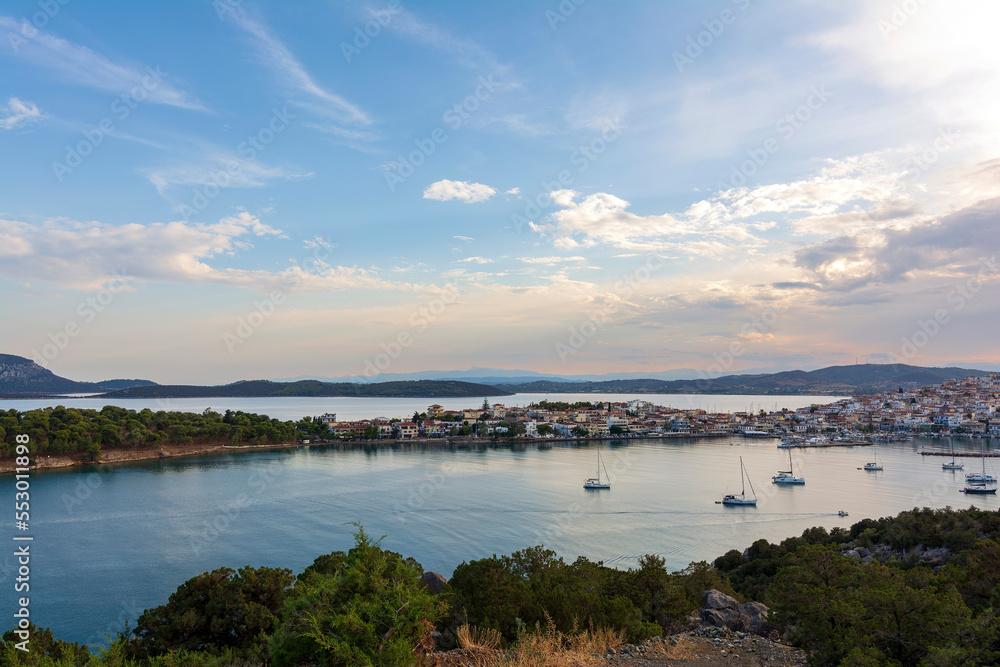 Beautiful view of Ermioni sea lagoon with moored yachts and boats at sunset time.