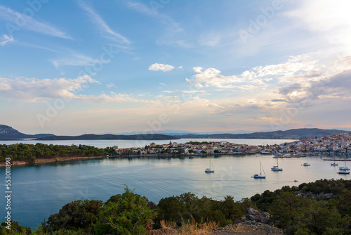 Beautiful view of Ermioni sea lagoon with moored yachts and boats at sunset time.
